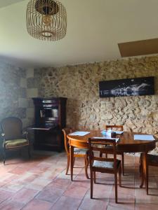 ein Esszimmer mit einem Tisch, Stühlen und einem Klavier in der Unterkunft La maison de l'Architecte - Gite proche Bordeaux in Salleboeuf