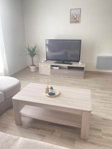 un soggiorno con TV e tavolino da caffè di Maison spacieuse de Lila avec 3 places de parkings a Crèvecoeur-le-Grand