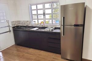 une cuisine avec un réfrigérateur en acier inoxydable et un évier dans l'établissement Sinta-se em casa com diversão!, à São Paulo