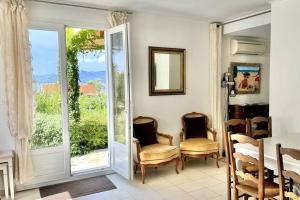a dining room with a table and chairs and a window at Maison Les aloes - vue mer et proche centre ville in Propriano