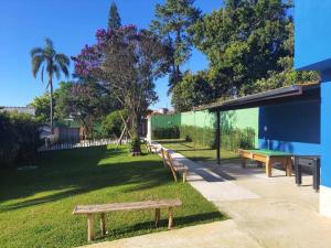 un groupe de bancs assis dans un parc dans l'établissement Sinta-se em casa com diversão!, à São Paulo