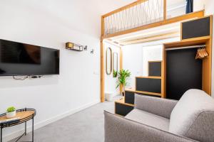 a living room with a couch and a tv at Tiendas 26 in Almería