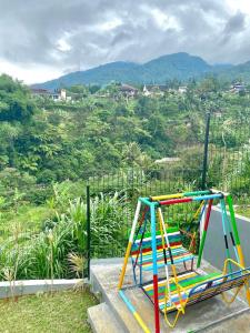 Un colorido parque infantil con vistas a la montaña. en Villa puncak6, en Campaka