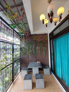 a dining room with a table and some windows at Classic 6 Home Stay Hatyai in Ban Tha Sae