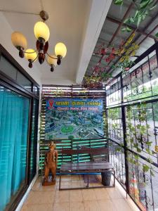 a bench in a building with a sign on the wall at Classic 6 Home Stay Hatyai in Ban Tha Sae
