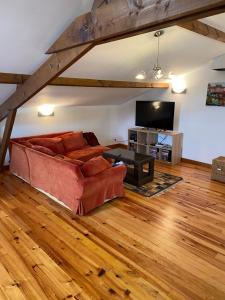 een woonkamer met een bank en een tv bij La Chillaudie in Verteillac