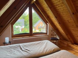 a bedroom with a large window in a attic at Müritzblick OG in Marienfelde +9 photos