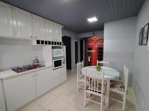 a kitchen with a table and a red phone booth at Apartamento London - Centro Nova Petrópolis in Nova Petrópolis +13 photos