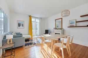 a living room with a table and a couch at Au bon air de Villers - plage à 200 mètres in Villers-sur-Mer