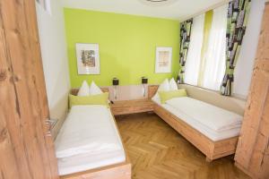 2 Betten in einem Zimmer mit grünen Wänden in der Unterkunft Lorenzerhof in Sankt Lorenzen am Wechsel
