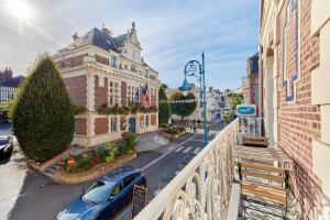 a car parked on a street in front of a building at Au bon air de Villers - plage à 200 mètres in Villers-sur-Mer