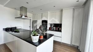 une cuisine avec des armoires blanches et un comptoir noir dans l'établissement Magnolienhaus, à Capelas