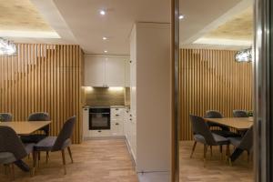 una cucina e una sala da pranzo con tavoli e sedie di Tara Lux apartmani a Kaludjerske Bare