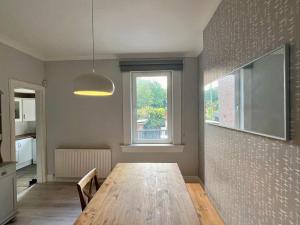 Un comedor con una mesa de madera y una ventana. en McLaren House, en Stirling