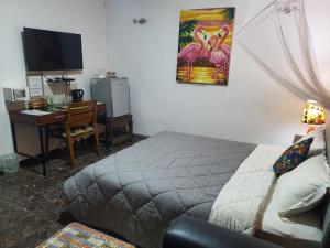 a bedroom with a bed and a desk with a computer at Villa Cacao in Abidjan