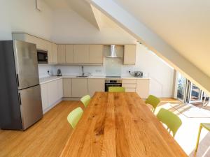 a kitchen with a wooden table and green chairs at Ocean View in Alnwick