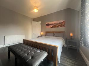1 dormitorio con cama y banco. en McLaren House, en Stirling