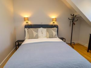a bedroom with a large bed with two lamps at Ocean View in Alnwick