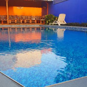 a swimming pool with a chair in a hotel at Villa Cacao in Abidjan