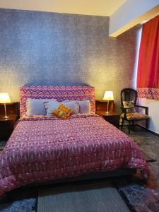 a bedroom with a red bed with two pillows at Villa Cacao in Abidjan +69 photos