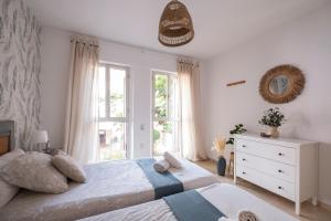 sypialnia z dwoma łóżkami i oknem w obiekcie Aquamarine apartment in Marina Sotogrande w mieście Sotogrande