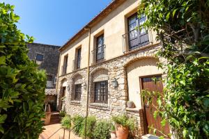 an old stone building with a bunch of windows at Hostal La Riera de Peratallada in Peratallada