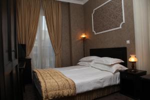 um quarto com uma cama grande e uma janela em Strimon Garden Medical SPA Hotel em Kyustendil