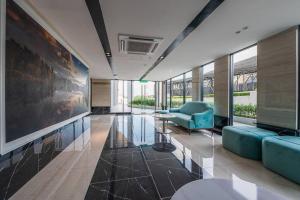 a lobby with a blue chair and a table in a building at Cheras Kuala Lumpur luxury condo in Cheras