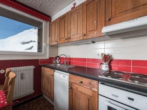małą kuchnię z drewnianymi szafkami i zlewem w obiekcie Studio spacieux avec balcon près des pistes et commerces, parking optionnel, animaux acceptés - FR-1-502-424 w mieście Tignes +2 zdjęcia