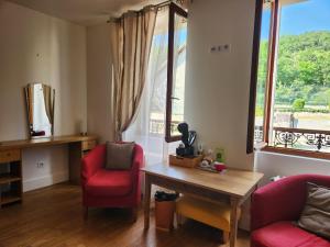 a living room with two chairs and a table and a window at BnB Confort in Bruère-Allichamps