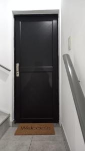 a black door with a welcome mat in front of it at Parque in Gualeguaychú
