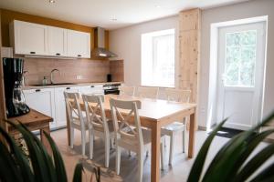 a kitchen with a wooden table and chairs at Un gîte en Creuse in Bord-Saint-Georges