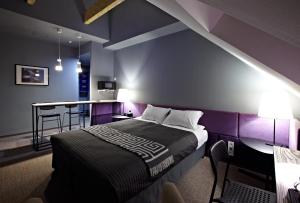 a bedroom with purple walls and a bed with a table at Newport in Dnipro