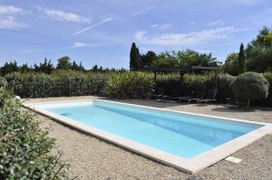 a swimming pool in a yard with chairs around it at Gîte Pierre Blanche in Visan