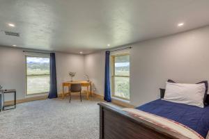 Un dormitorio con una cama, un escritorio y ventanas. en 1427 County Road 400, en Pagosa Springs