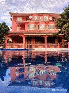 une grande maison se reflète dans une mare d'eau dans l'établissement Villa 9BR, à Flic-en-Flac