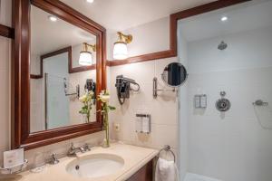 a bathroom with a sink and a mirror and a shower at Hotel Barsey by Warwick in Brussels