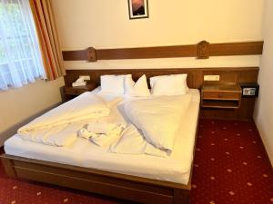 图克斯Zum Sepp的卧室里有一张床，床单和枕头都是白色的