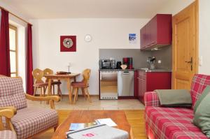 a living room with a couch and a kitchen at Ferienwohnungen Wendelstein in Bad Feilnbach