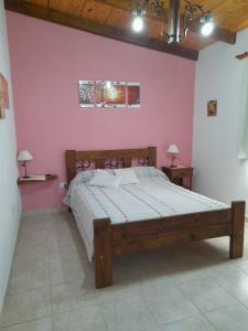 een slaapkamer met een groot bed in een roze muur bij Cabañas Brisas Del Mirador in Bialet Massé +32 foto's