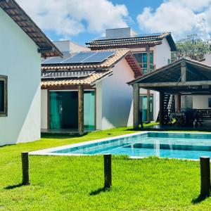 una casa con piscina nel cortile di Pousada Bangalos Corais da Pitinga Arraial d'Ajuda a Porto Seguro