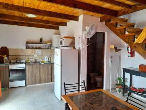 een keuken met een witte koelkast en houten plafonds bij Cabañas Brisas Del Mirador in Bialet Massé