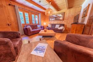a living room with couches and a table in a cabin at Chalet Ski-In Plagnat, Ardent in Montriond