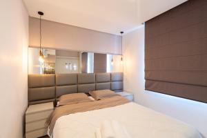 ein Schlafzimmer mit einem großen Bett und einem Spiegel in der Unterkunft Apto a 10 min da Vila Germânica, dois quartos, salas de estar e jantar, cozinha completa, sacada com churrasqueira, Wi-Fi, Piscina, academia, mercadinho 24 horas e Vaga de garagem in Blumenau + 22 Fotos