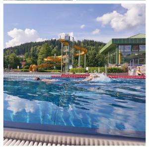 a swimming pool with a water slide in the background at Ferienwohnung Goldfasan in Lam