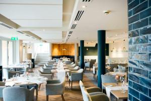 a dining room with white tables and chairs at Portmarnock Resort & Jameson Golf Links in Portmarnock