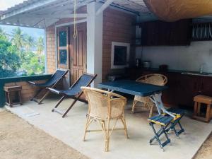 a patio with chairs and a table and a kitchen at RedBrick House Rumassala in Galle