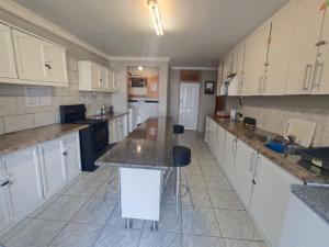 a large kitchen with white cabinets and a counter at Brix 7 single beds in Johannesburg +13 photos