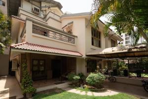 a large white house with a balcony and a yard at Super Luxury Villa - Near to Karnavati Club in Ahmedabad