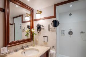 a bathroom with a sink and a mirror and a shower at Hotel Barsey by Warwick in Brussels